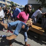 A Palestinian carries a wounded boy following what witnesses said was an Israeli air strike at a U.N.-run school in Rafah