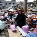 Palestinian woman reacts as she collects her belongings from her house which witnesses said was destroyed in an Israeli air strike, in Rafah in the southern Gaza Strip