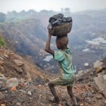 A boy carries coal at an open cast coal field at Dhanbad district in the eastern Indian state of Jharkhand.