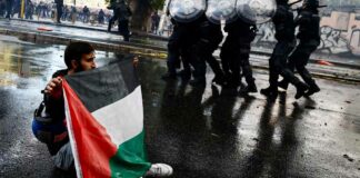 இத்தாலியின் ரோமில் நடந்த போராட்டத்தில் பாலஸ்தீனக் கொடியை ஏந்தியபடி ஒருவர்.